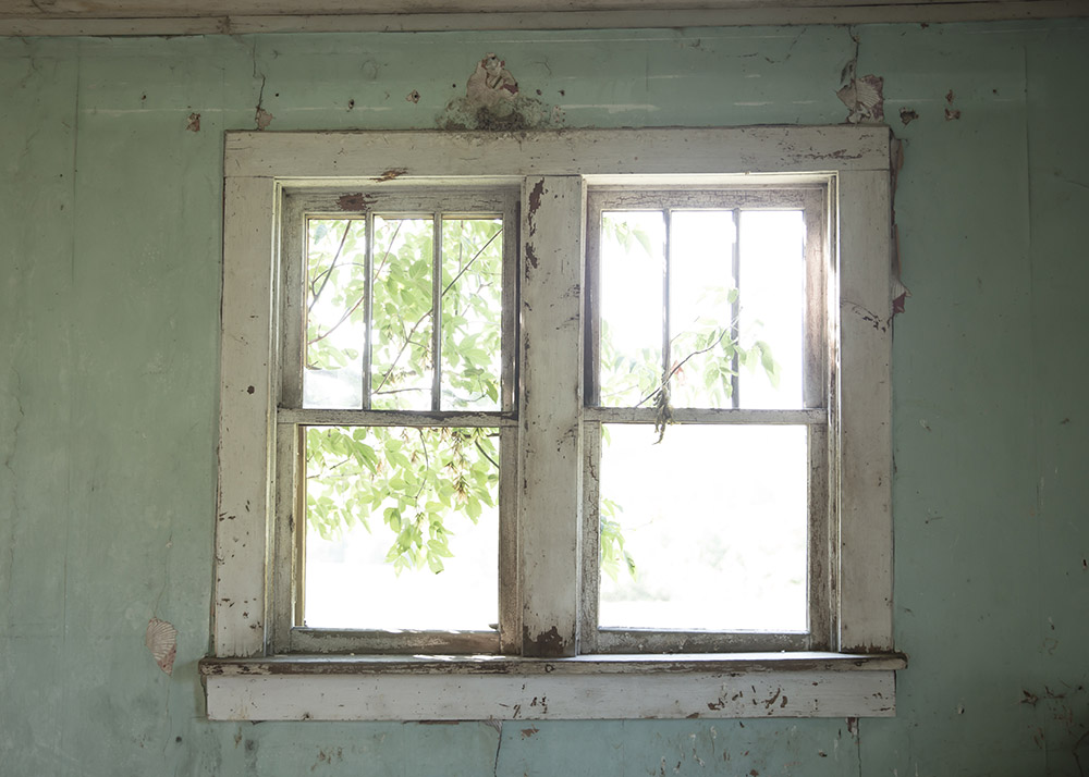 a photo of a window taken inside an abandoned homestead