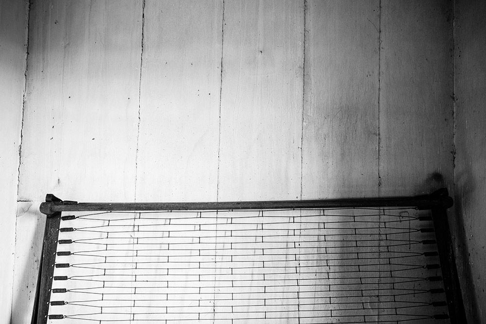 a black and white photo of an old bed frame