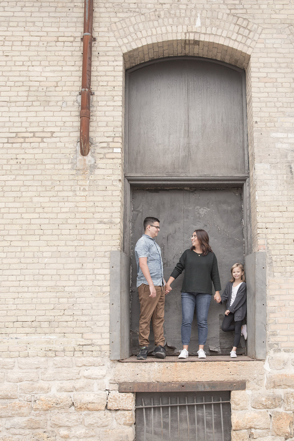 a family photo of a mother and her children in an old loading dock doorway