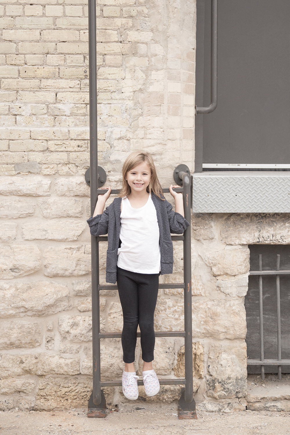 a photo of a young girl standing on a steel ladder