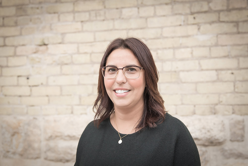 a portrait of a woman standing in front of a brick wall
