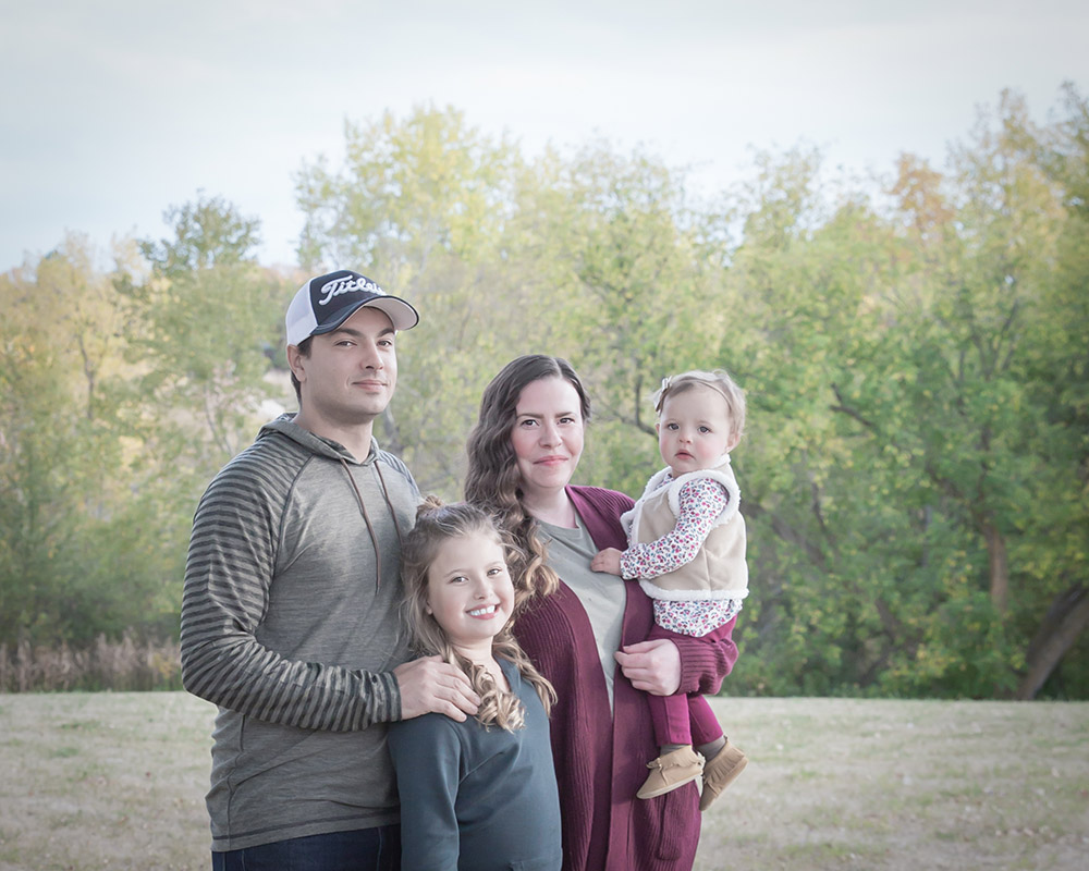 a family photo of a young family, taken in fall