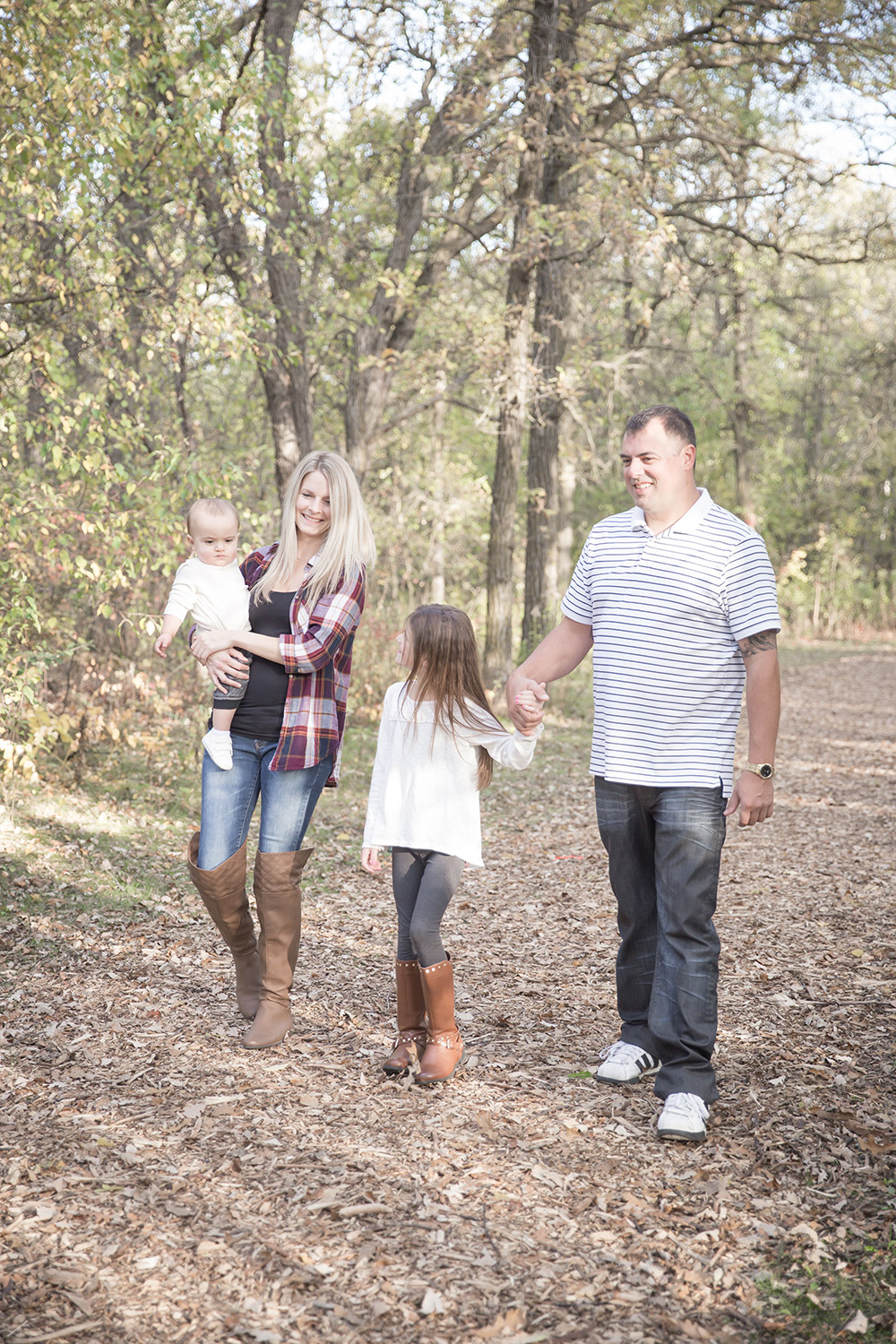 a photo of a young family walking down a path in autumn