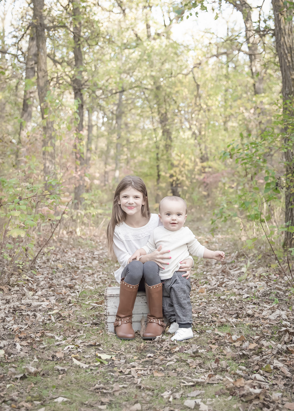 a photo of a young girl with her little brother in the fall