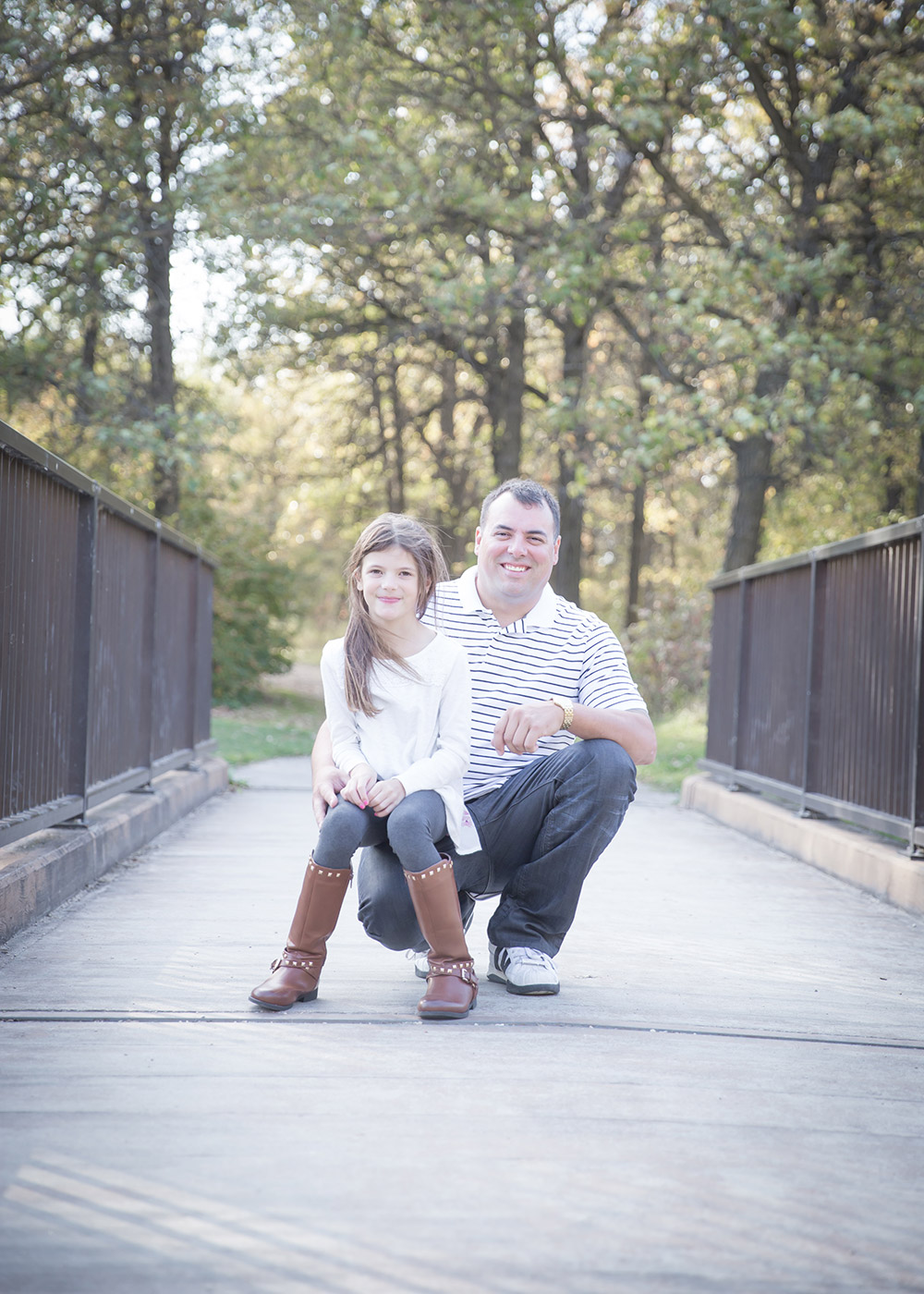 a photo of a father and daughter on a bridge