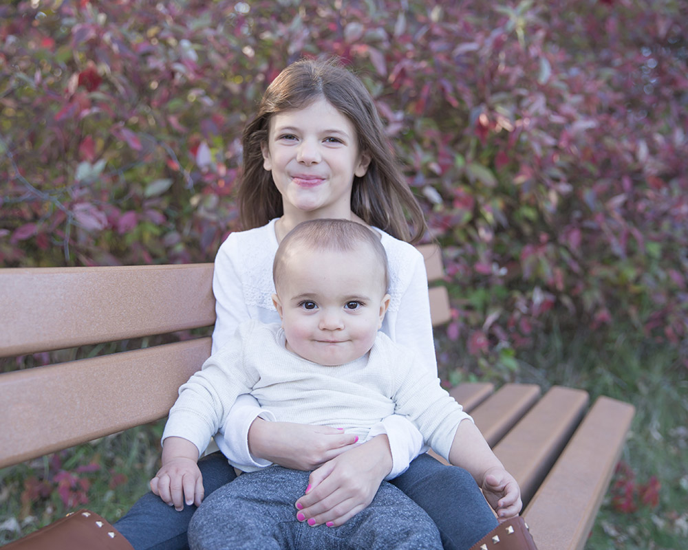 a photo of a young brother being held by his sister