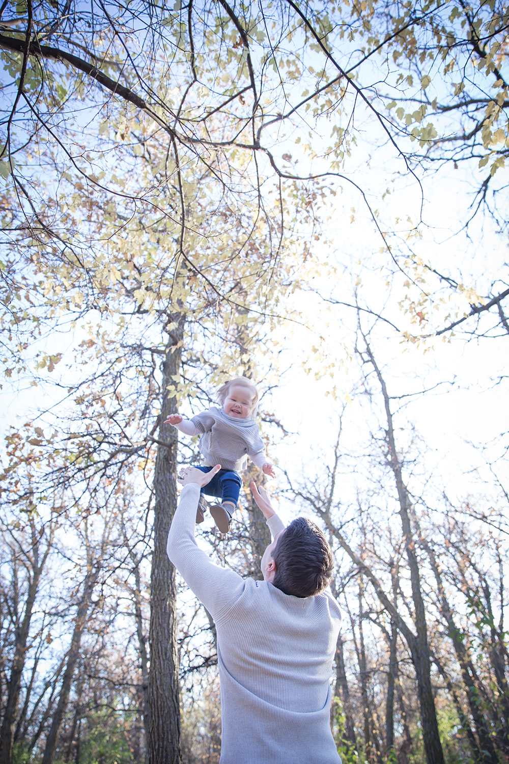a photo of a father tossing his daughter up into the air