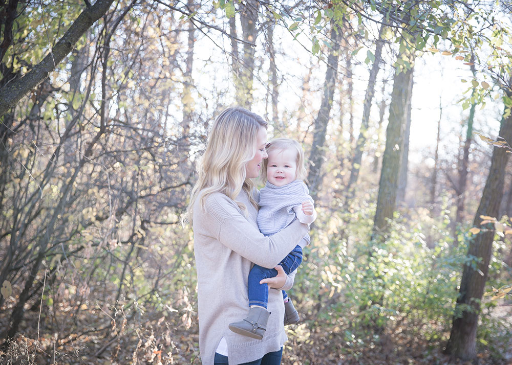 a photo of a mother and daughter in the woods in fall