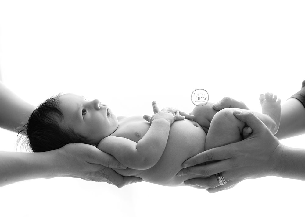a photo of a baby boy being held in his parents hands