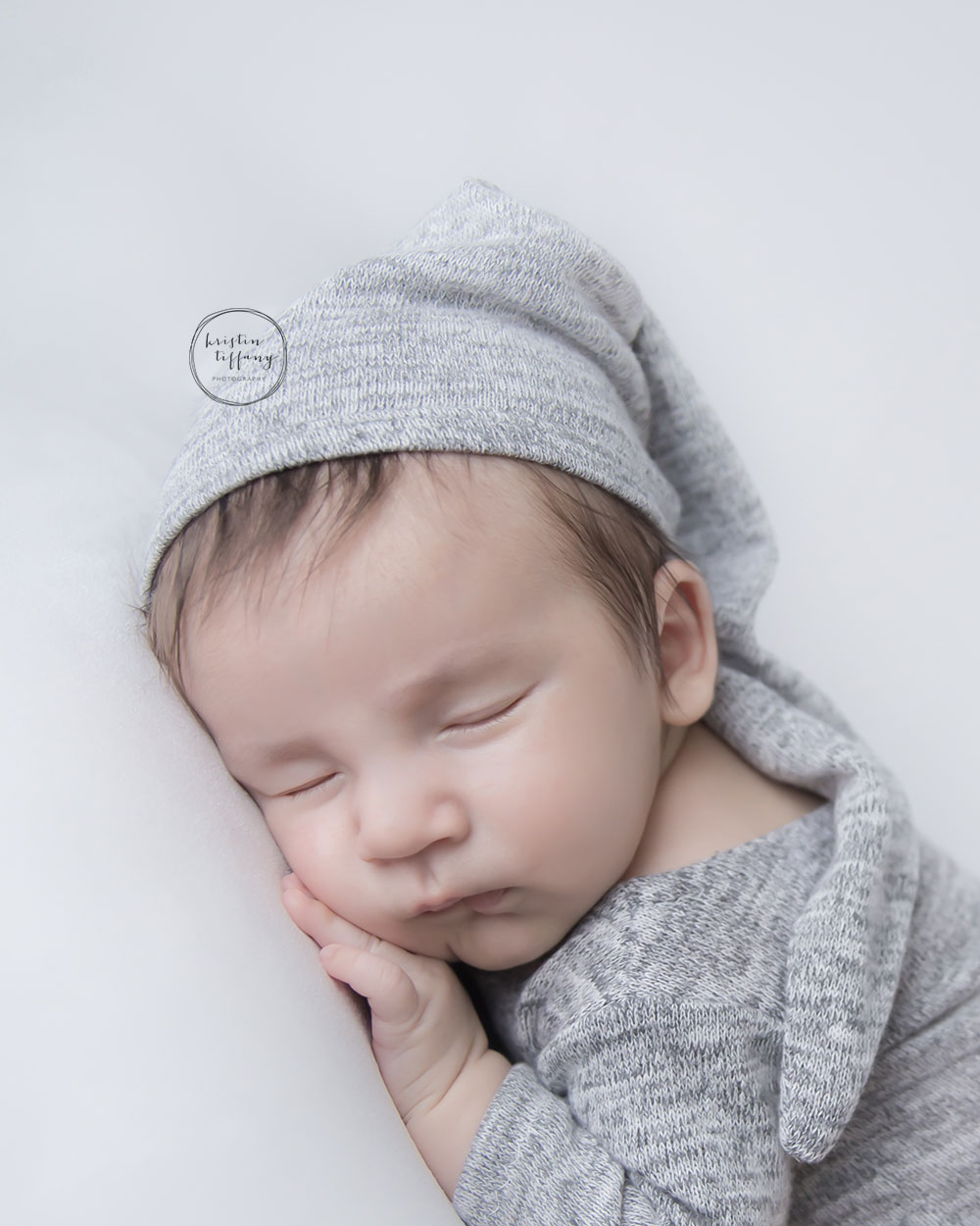 a photo of a baby boy sleeping wearing a sleeping cap
