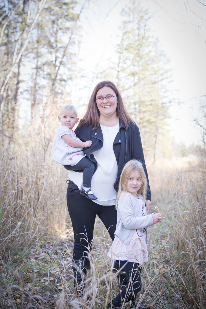 a photo of a mother with her two daughters in the long fall grass