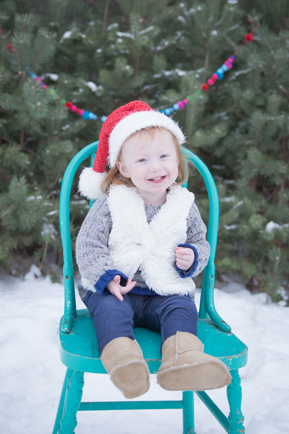 a photo of a young girl wearing a santa hat outside in the winter