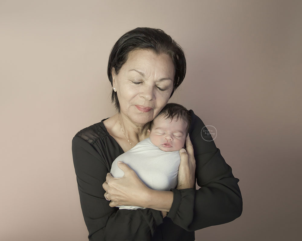a photo of a newborn baby boy with his grandmother