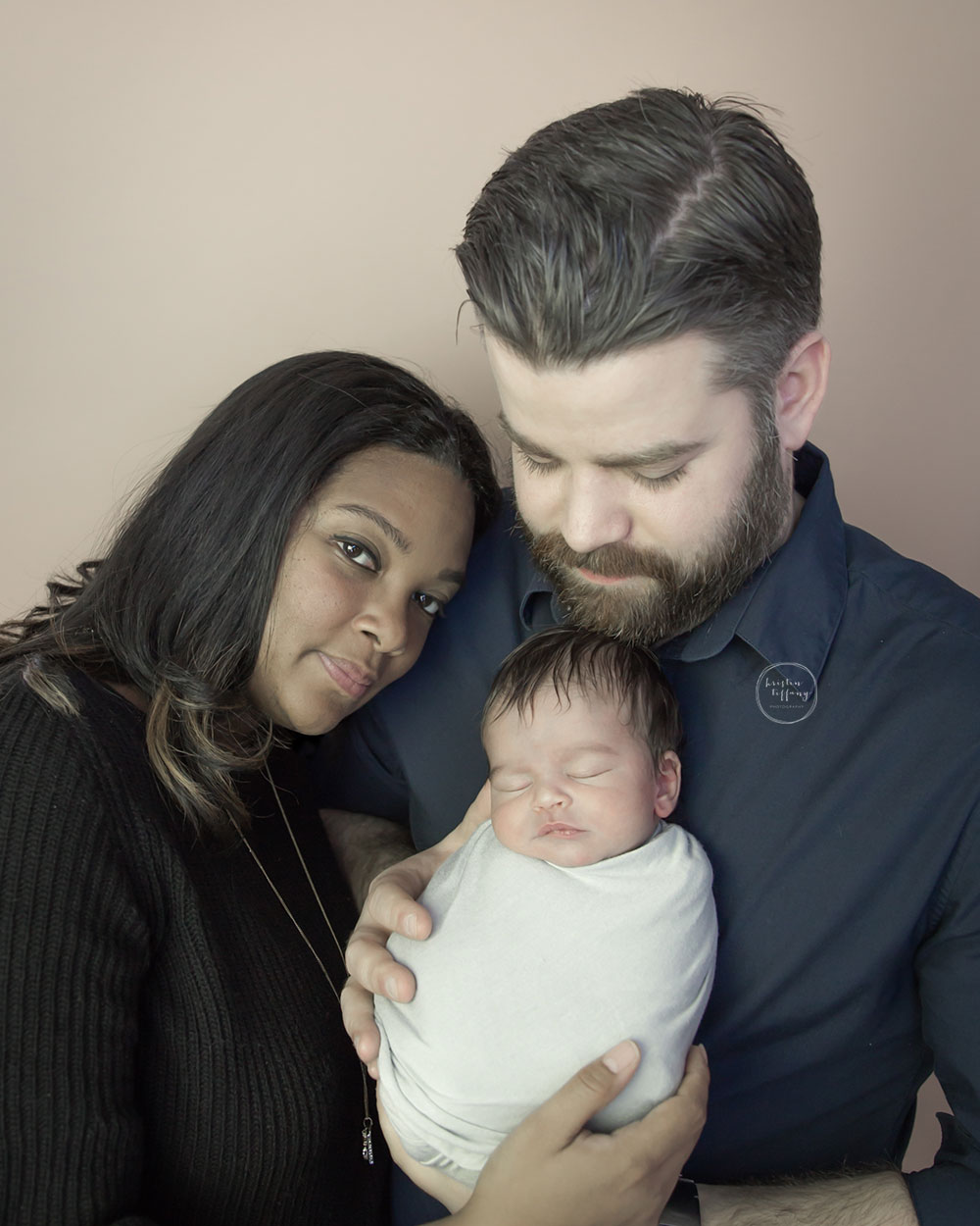 a photo of new parents with their newborn baby boy