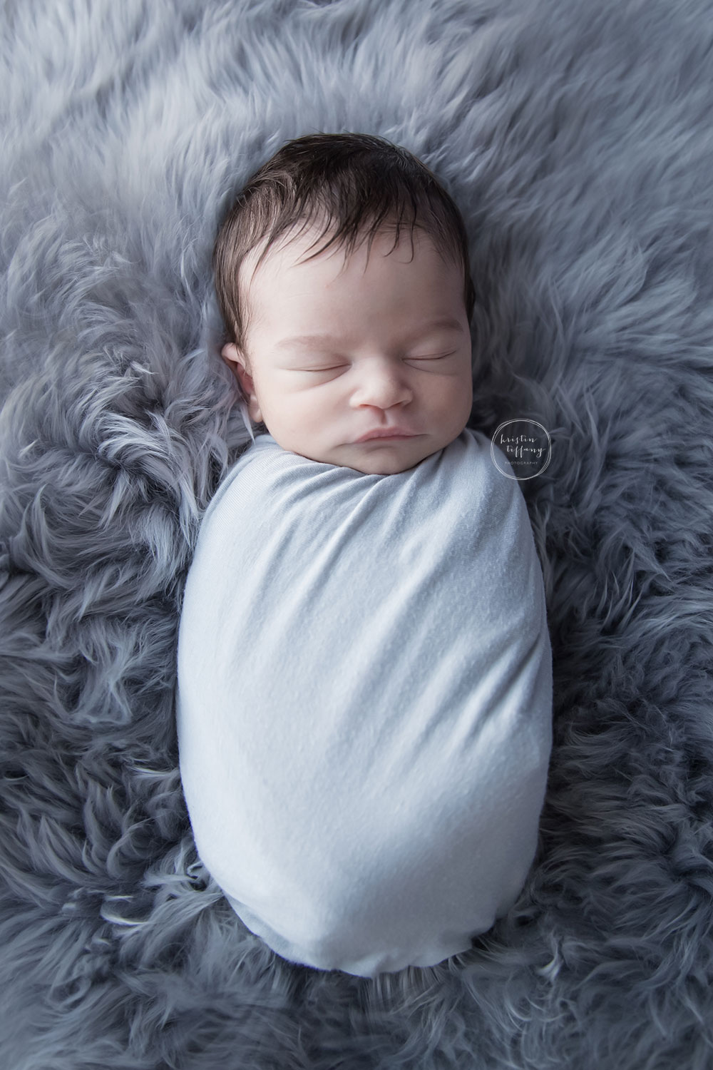 a photo of a swaddled newborn baby boy