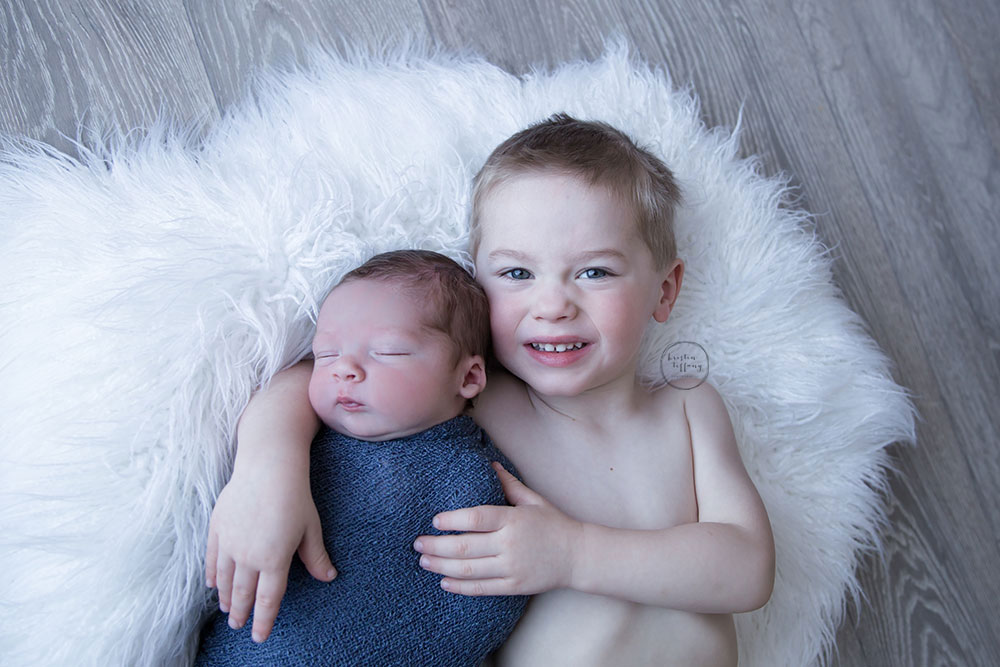 a photo of a newborn baby boy with his big brother