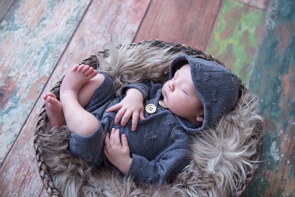 a newborn photo of a baby boy in a basket