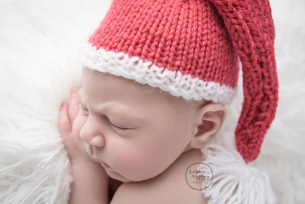 a photo of a newborn wearing a santa hat