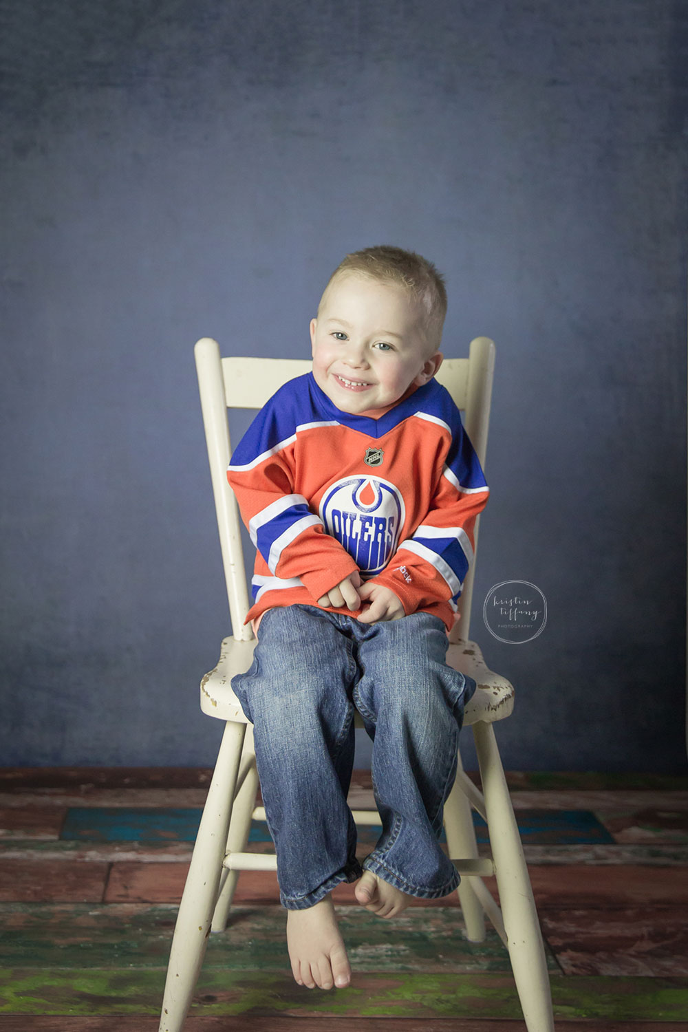 a photo of a little boy wearing an Oilers hockey jersey