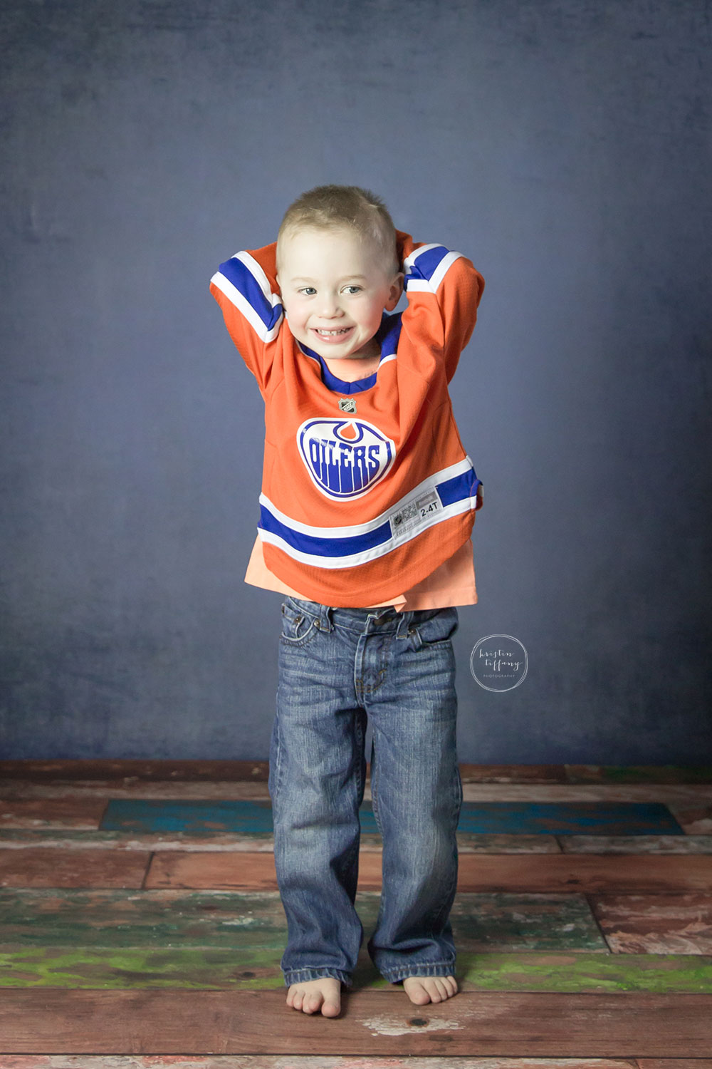 a photo of a little boy wearing an Oilers hockey jersey