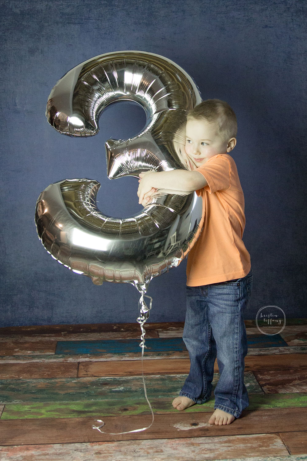 a photo of a little boy holding a large 3 balloon
