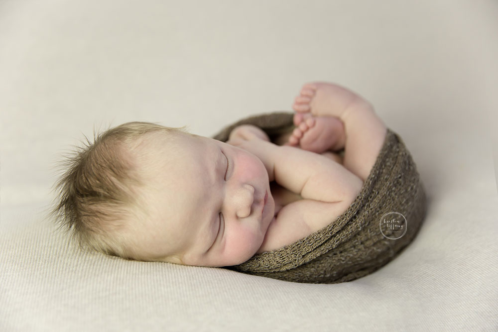 a photo of a posed sleeping baby boy