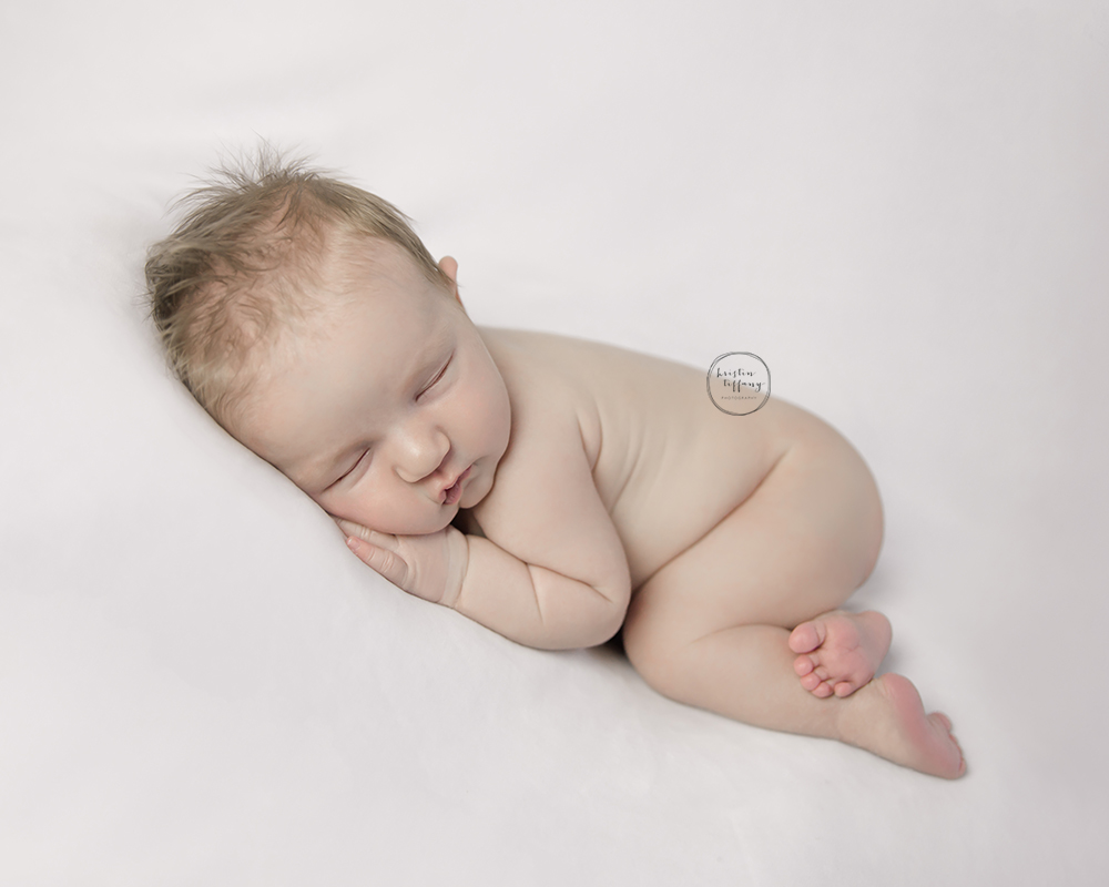 a photo of a newborn baby girl posed sleeping