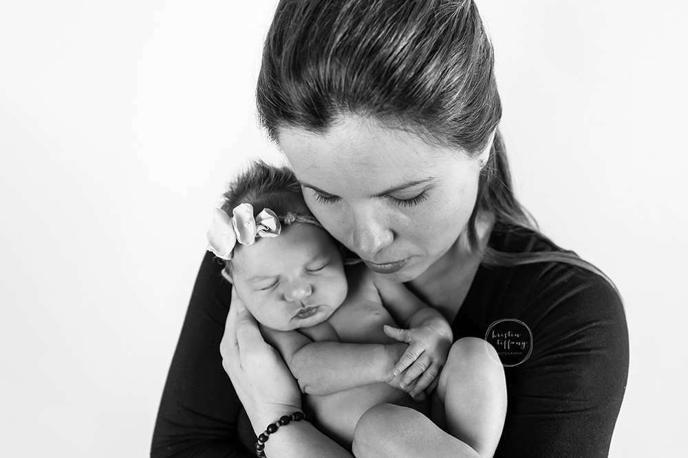 a photo of a newborn baby girl posed in her mother's arms