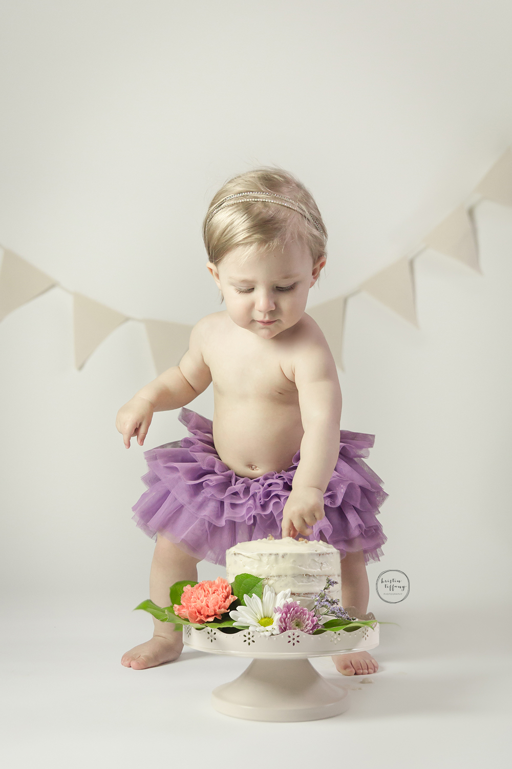 a photo of a baby girl at her first birthday cake smash