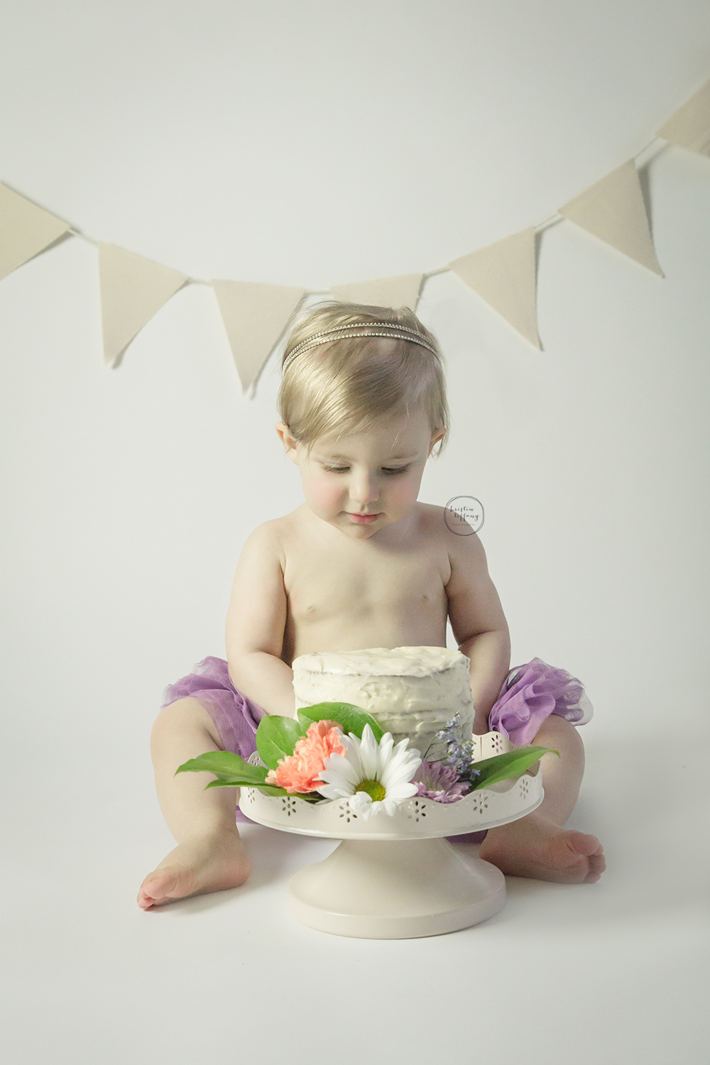 a photo of a baby girl with a cake smash cake
