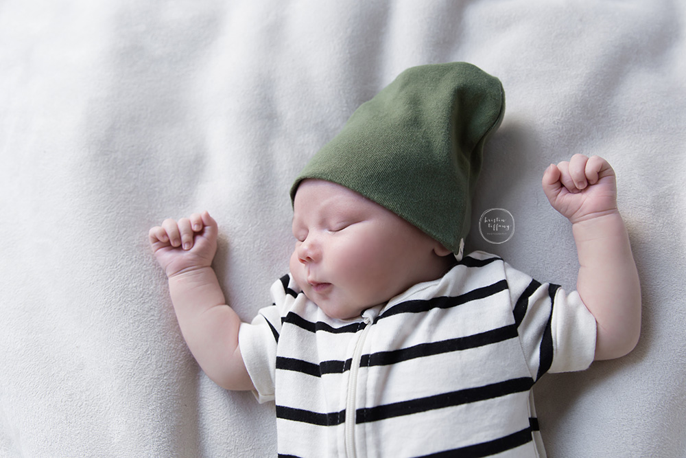 a photo of a newborn baby boy sleeping in a green beanie