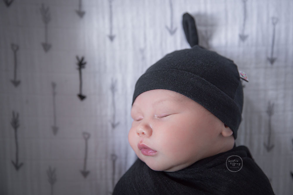 a photo of a baby boy sleeping in a cute hat