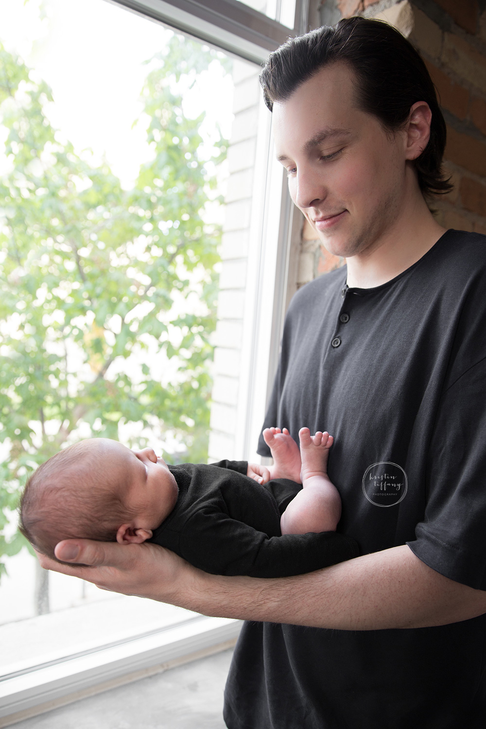 a photo of a father holding his newborn son
