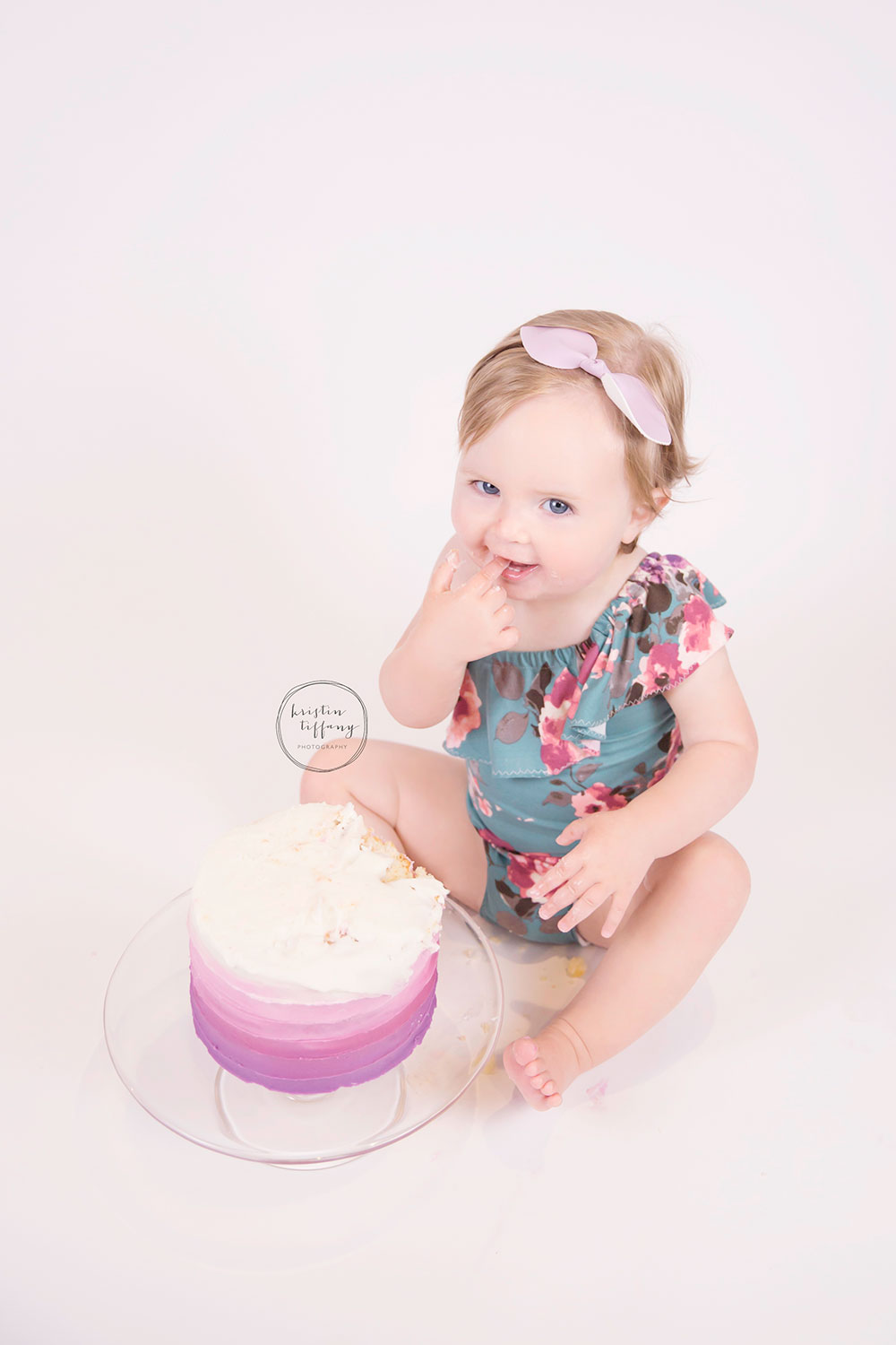 a photo of a baby girl eating a cake smash cake