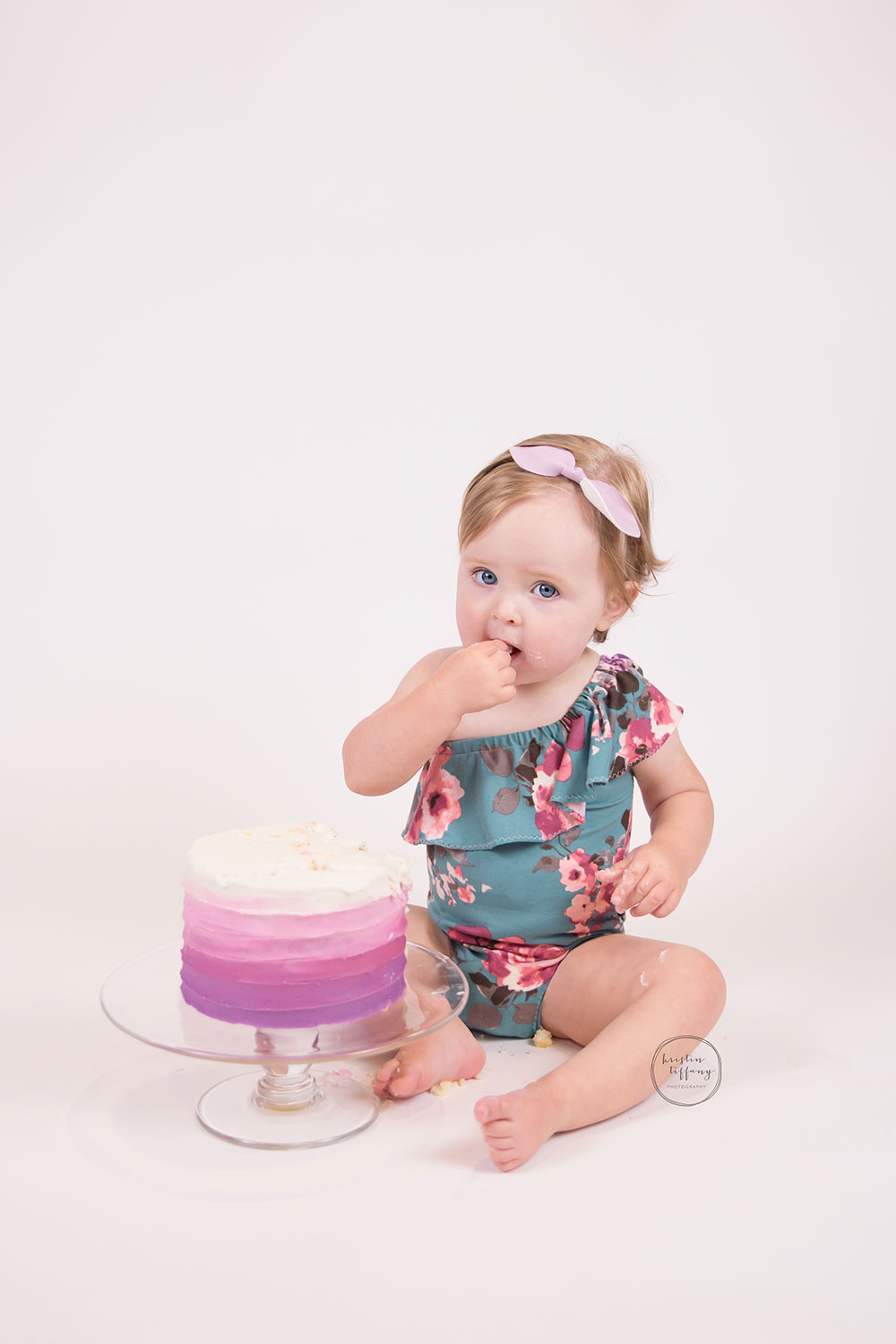 a photo of a baby girl eating a cake smash cake
