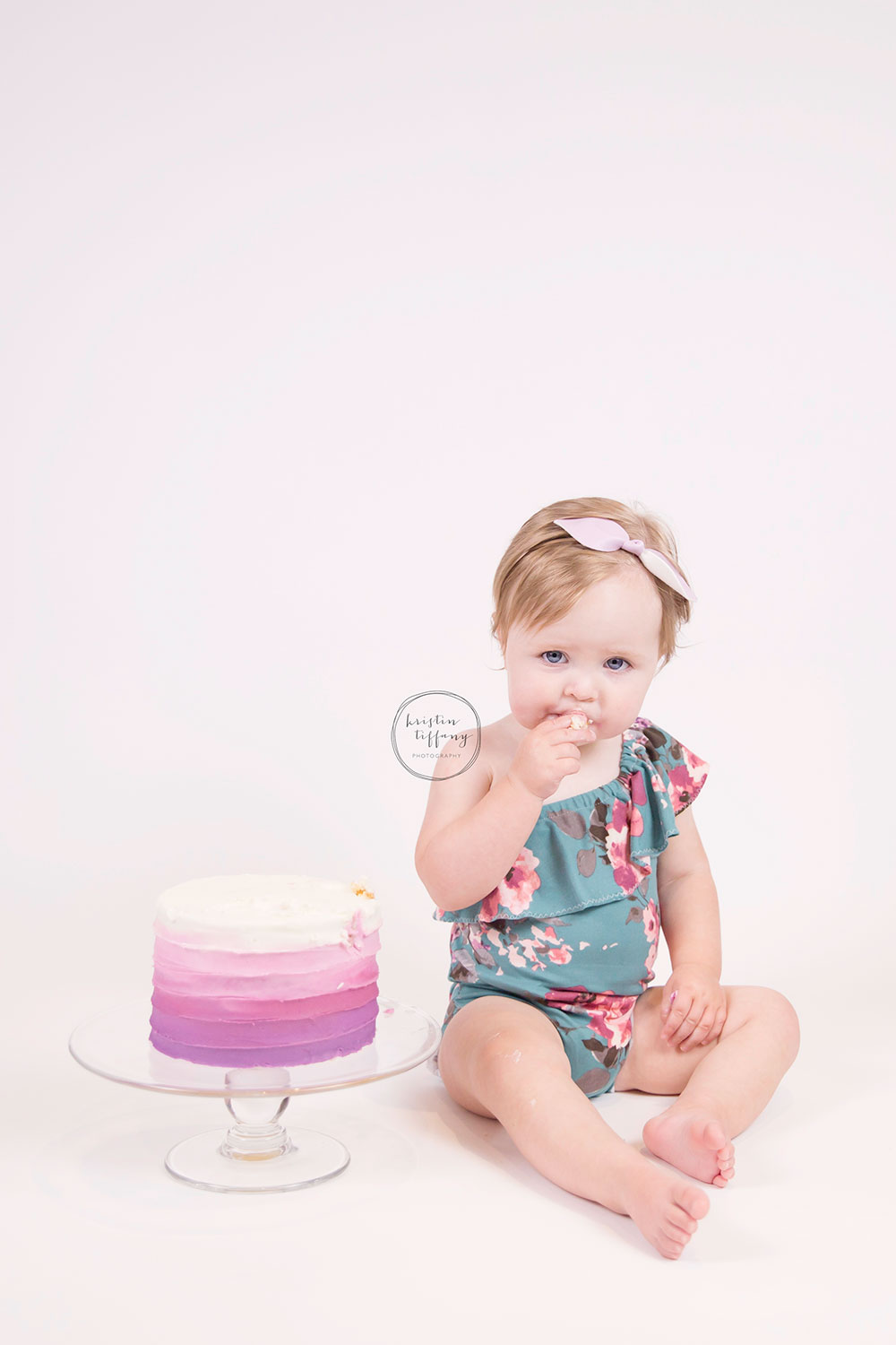 a photo of a baby girl eating a cake smash cake