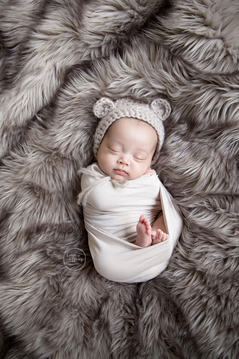 a photo of a baby boy wearing a bear bonnet