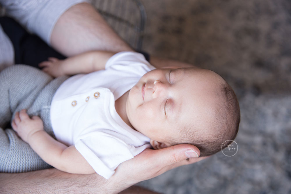 a photo of a baby smiling in his dads hands