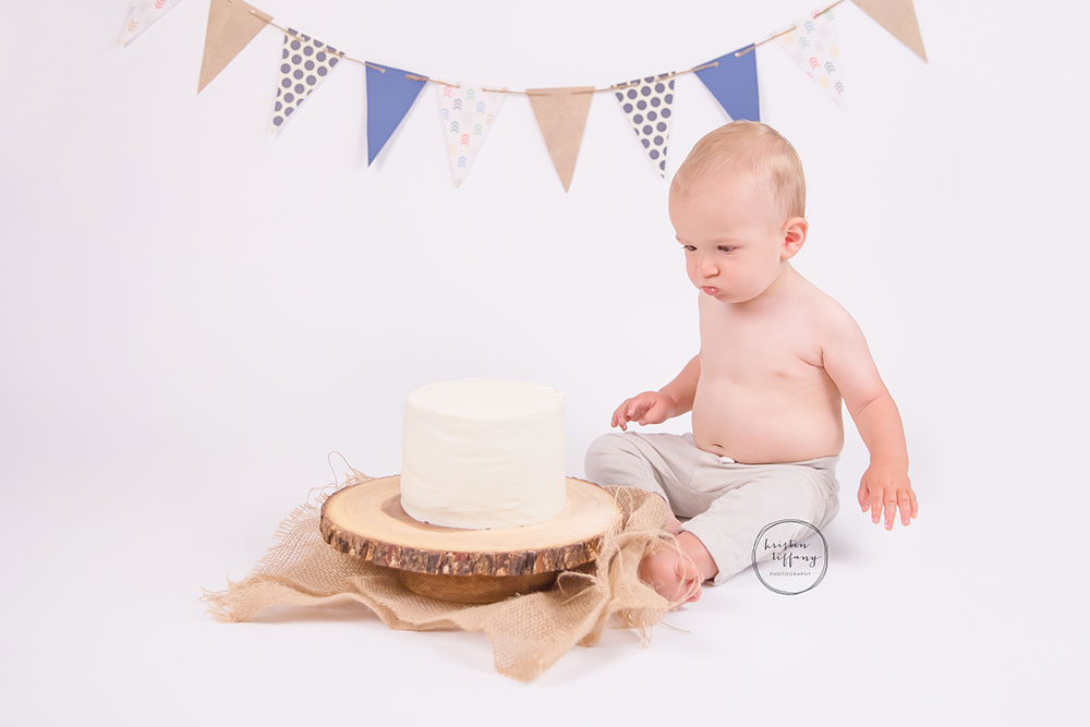 a photo of a baby boy with a cake smash cake