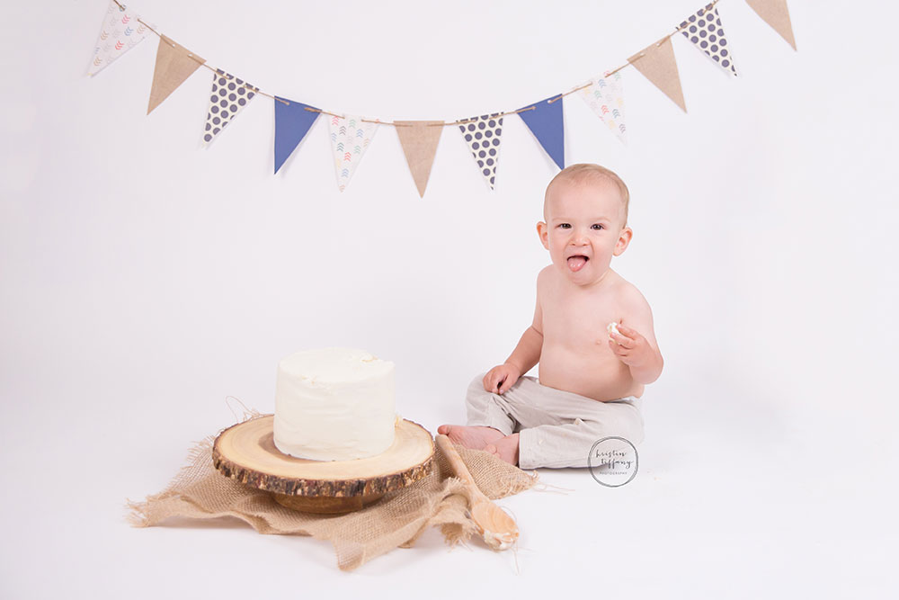 a photo of a baby boy with a cake smash cake and wooden spoon