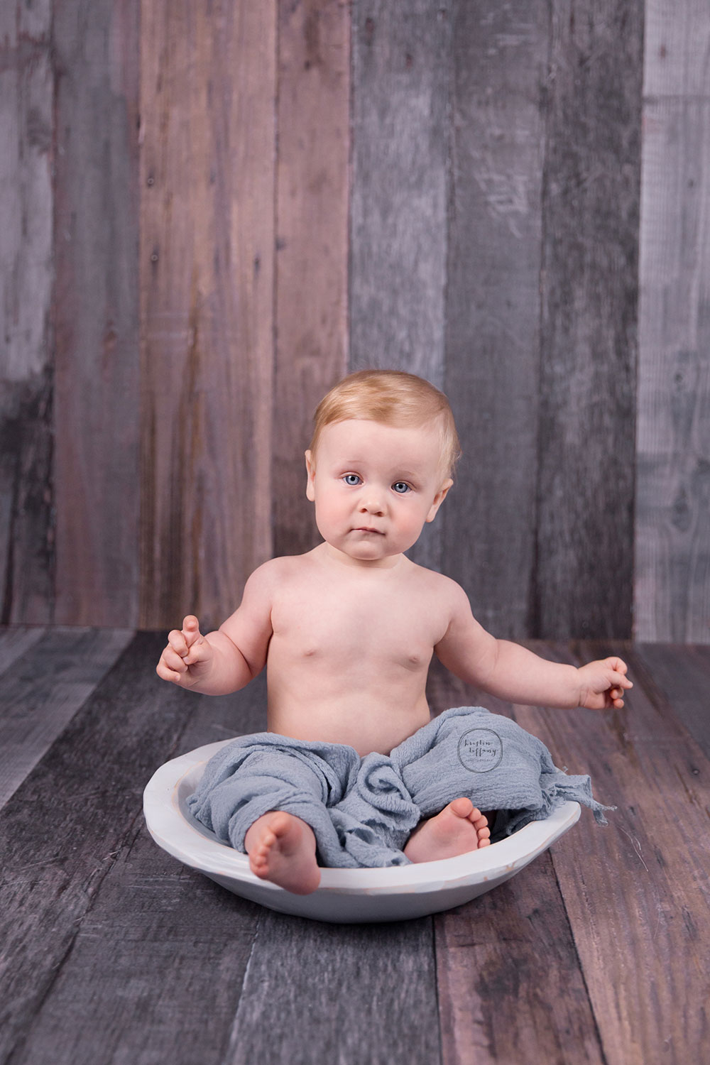 a photo of a baby boy in a wooden bowl