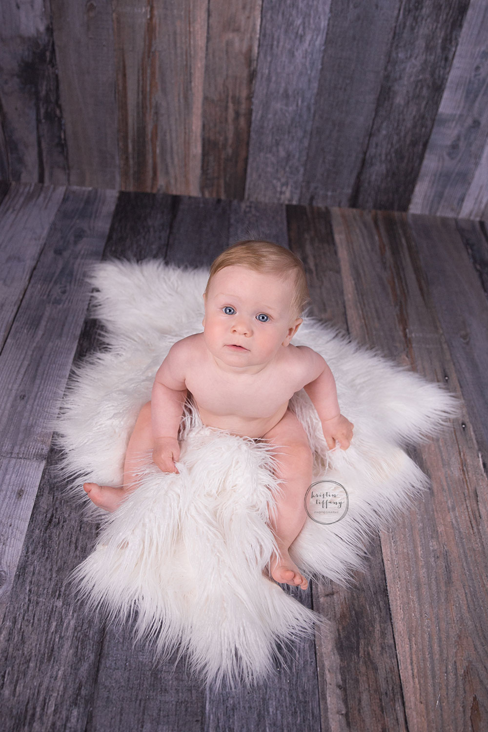 a photo of a baby boy on a fur rug