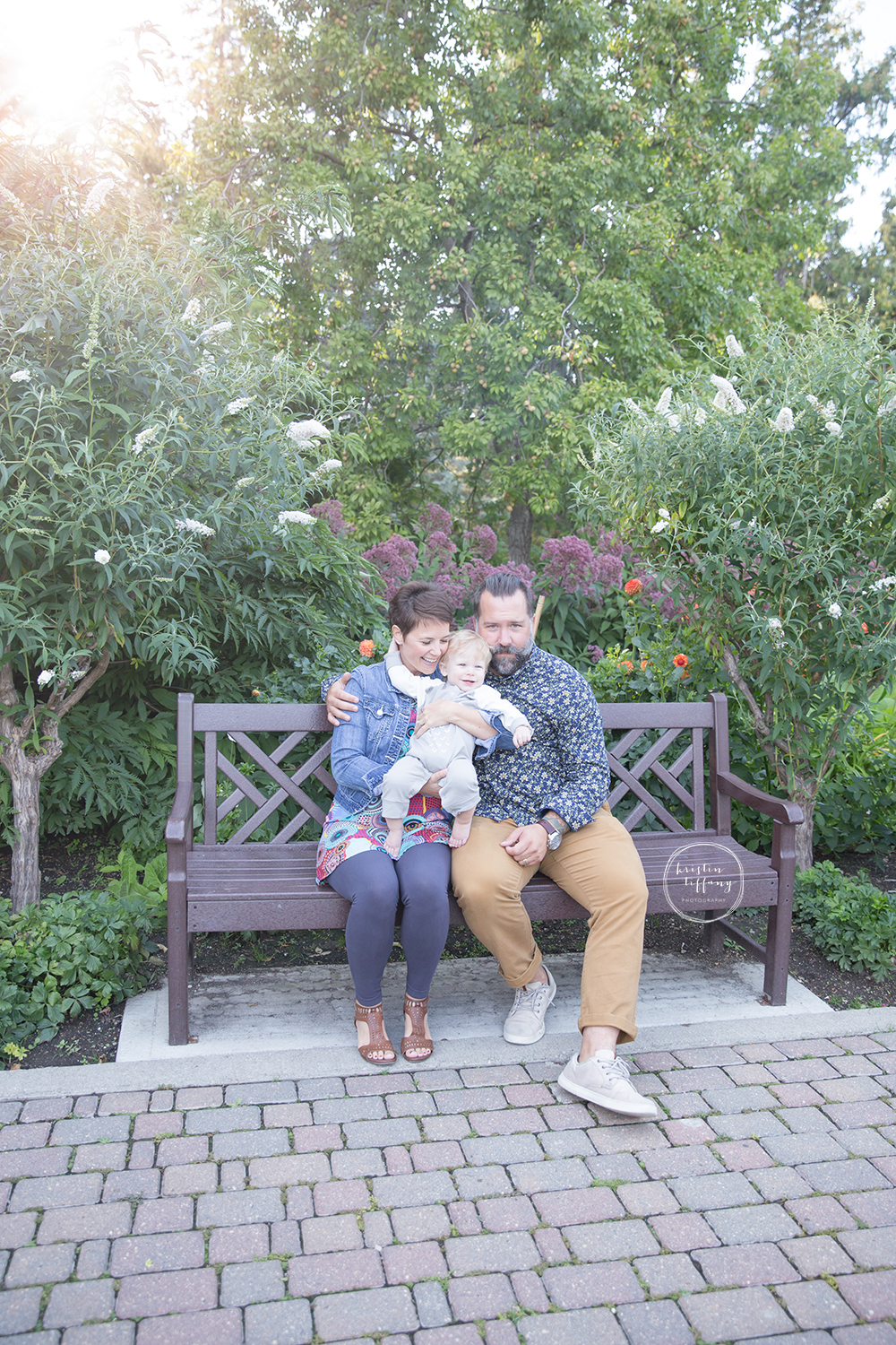 a photo of a family sitting on a park bench