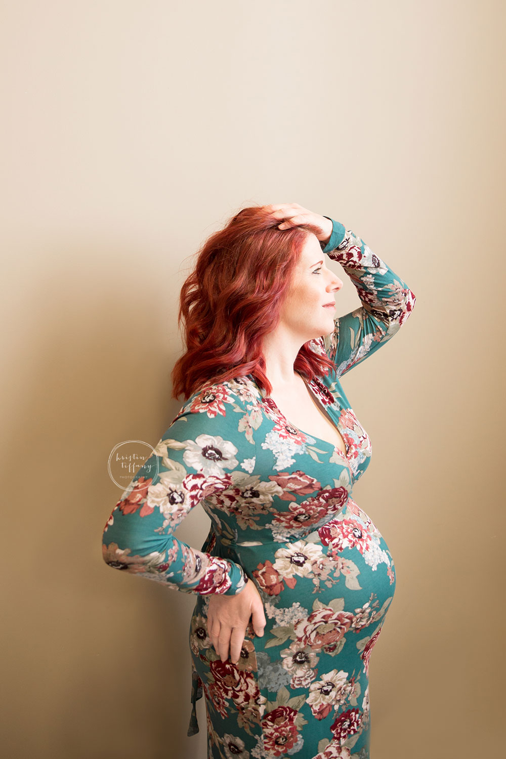 a maternity photo of a woman in a floral gown