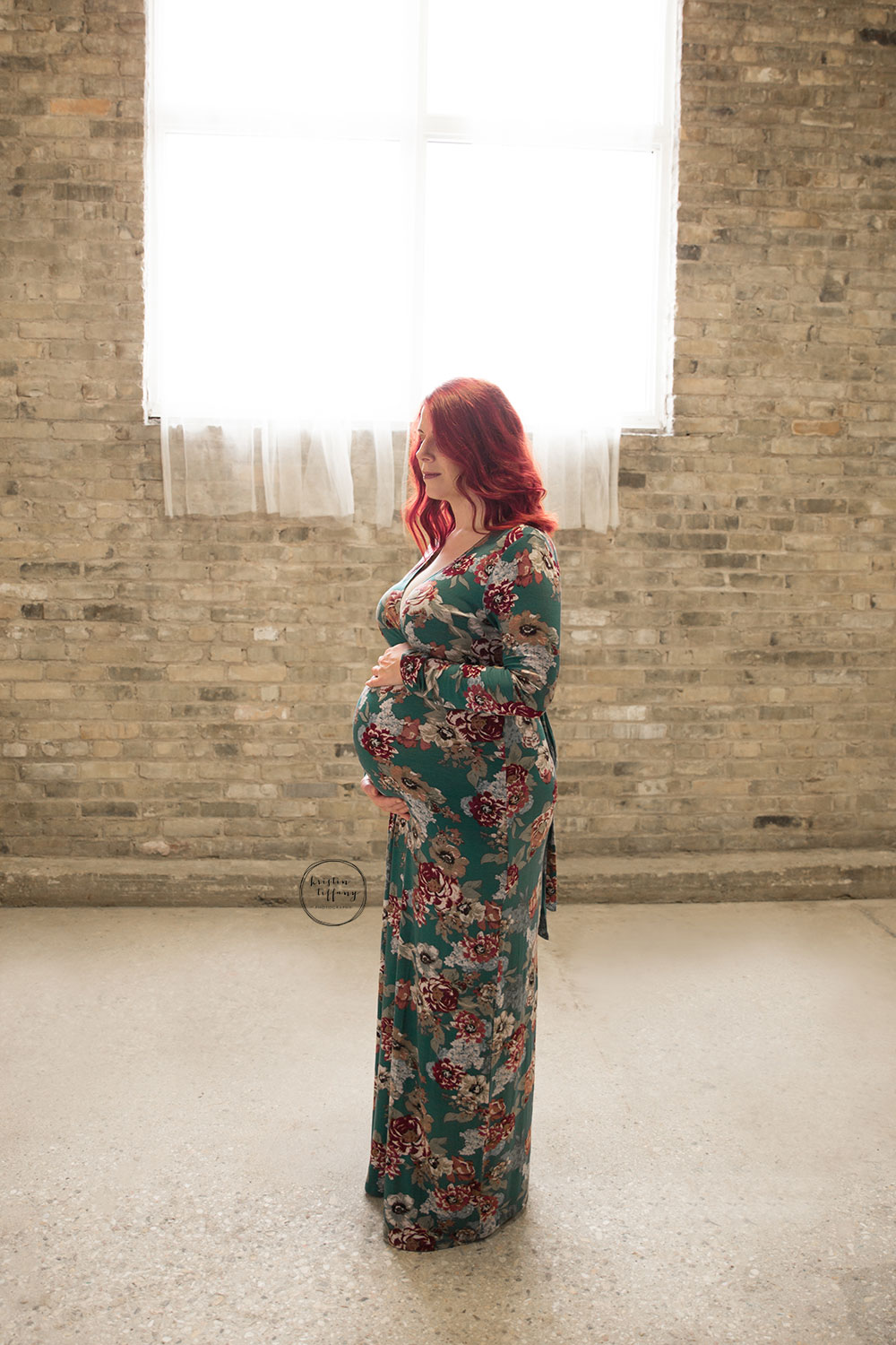 a maternity photo of a woman in a floral dress