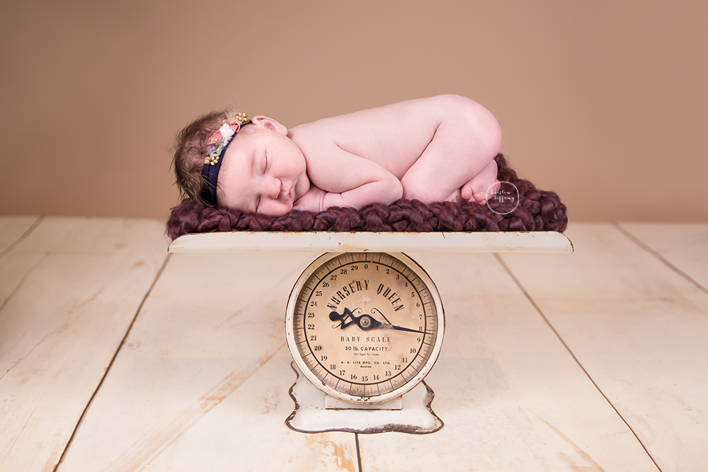 a photo of a newborn baby girl on a nursery scale