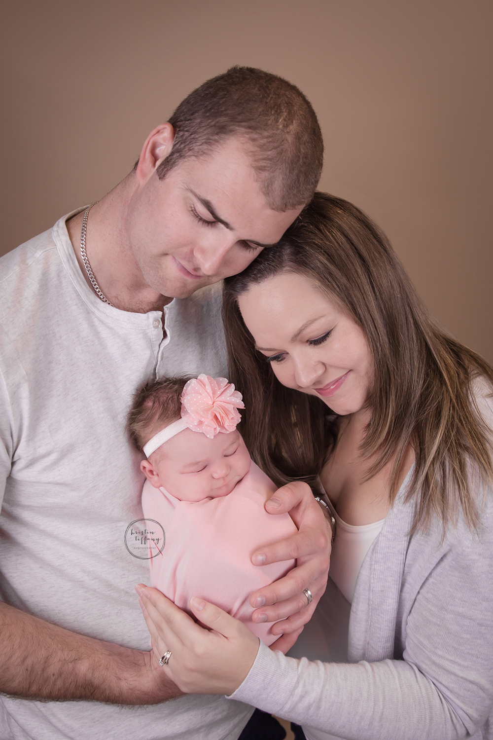 a photo of a newborn with her parents