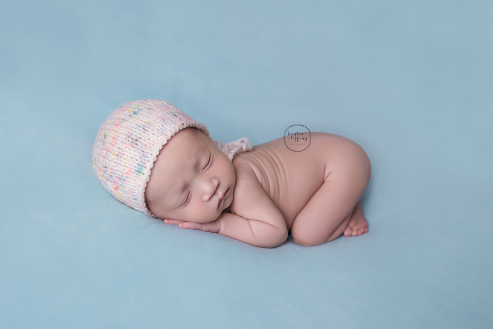 a photo of a posed newborn on a blue blanket