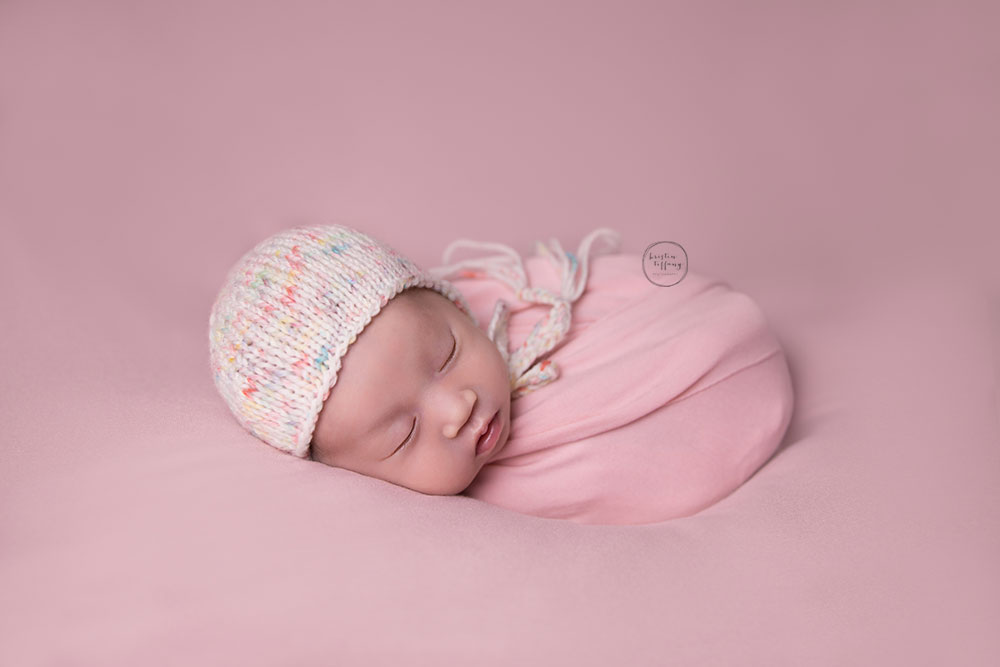 a photo of a newborn baby girl in a bonnet