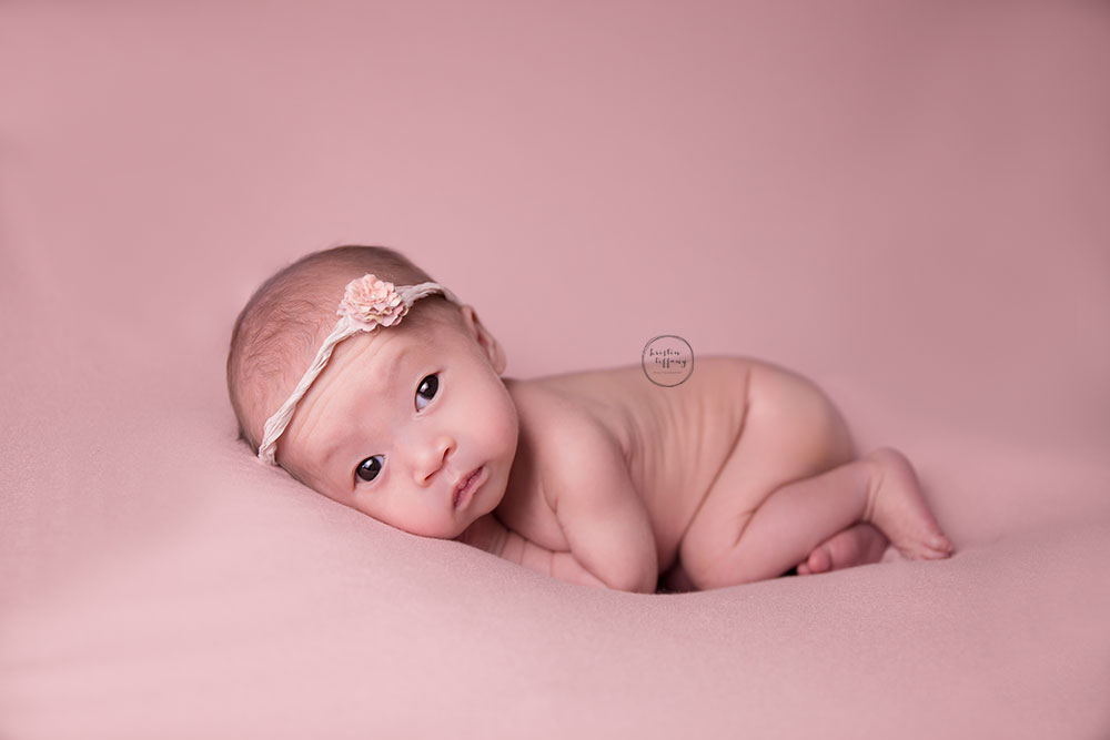 a photo of a newborn baby girl on a pink blanket